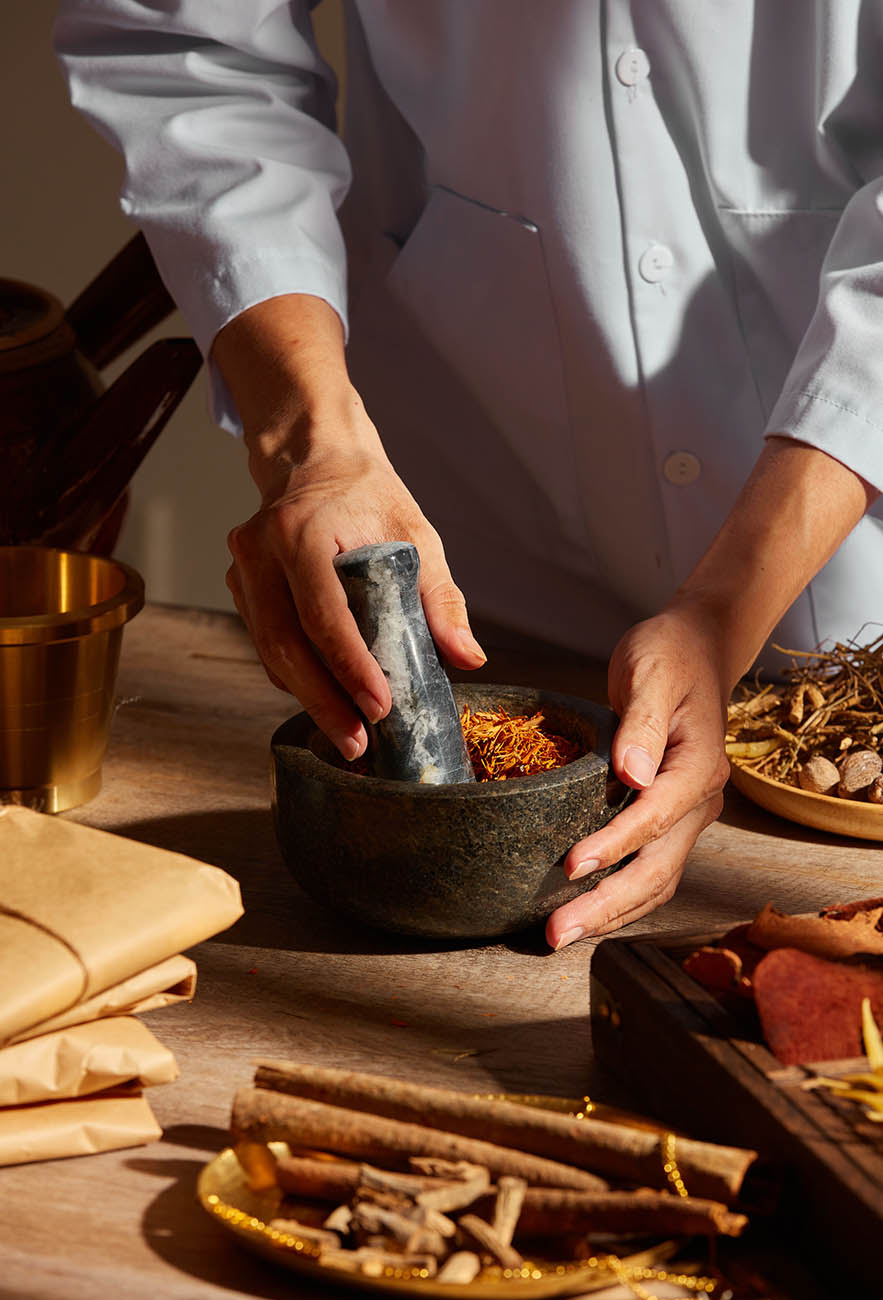 practitioner preparing Chinese herbal medicine